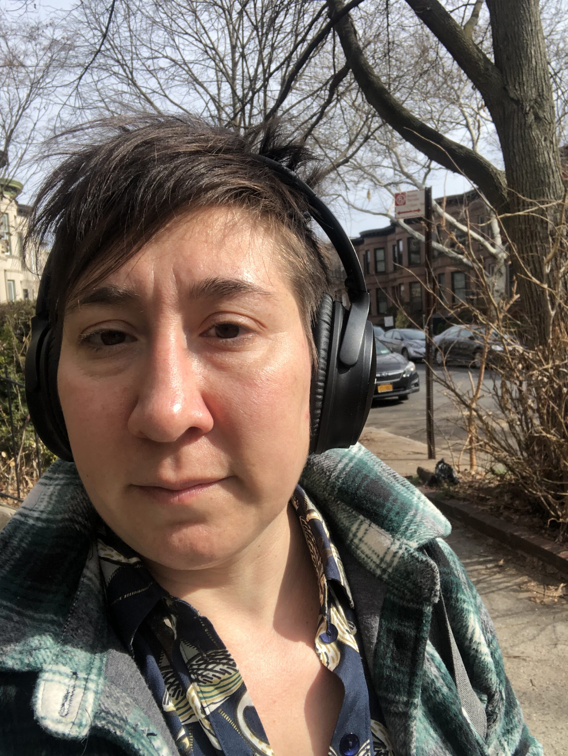Davida has a slight smile and is wearing headphones on a winter's day.