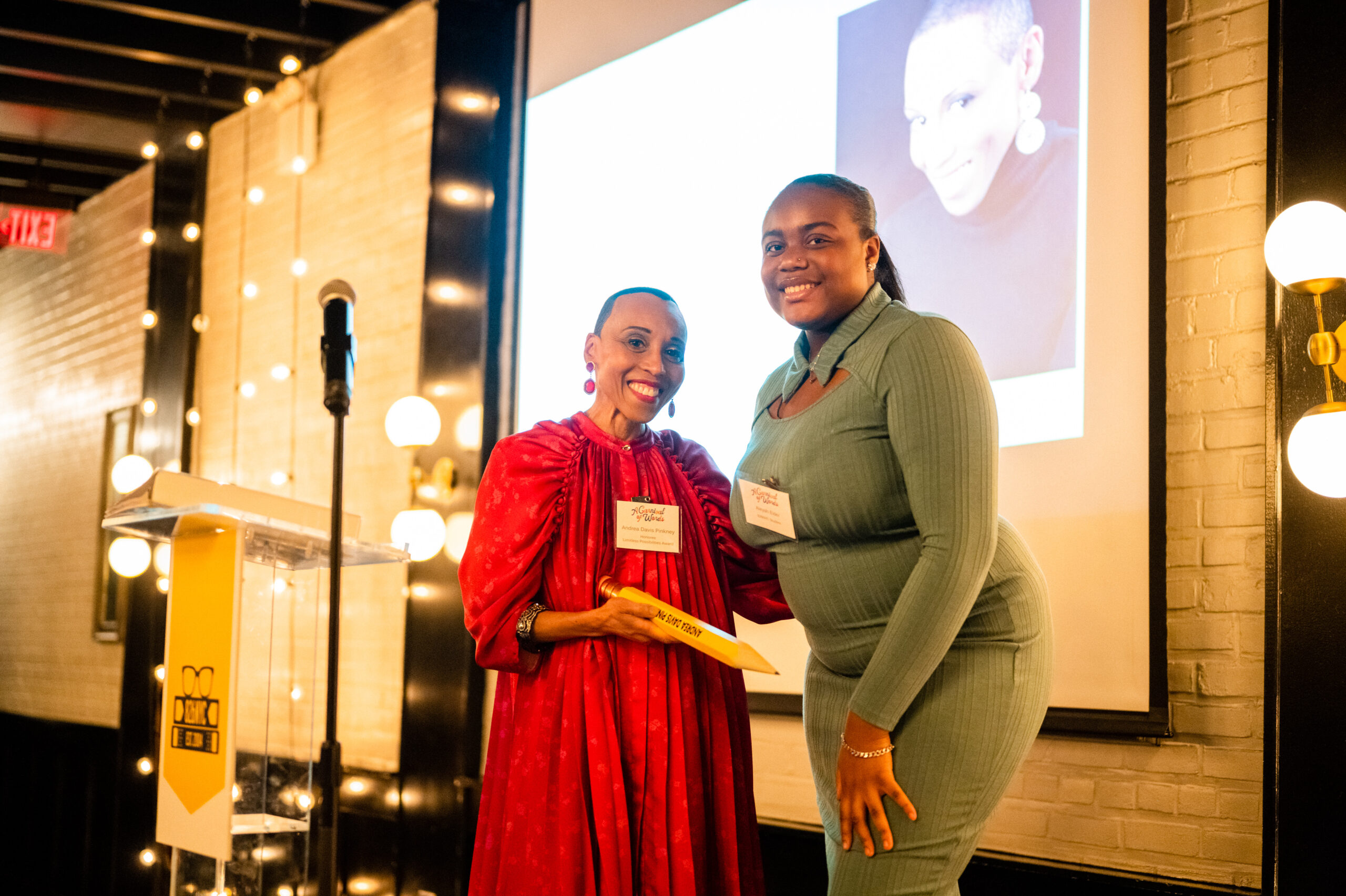 La estudiante de 826NYC Aleyah Elder con la autora Andrea Davis Pinkney en el escenario de la celebración Write the Future de 2023