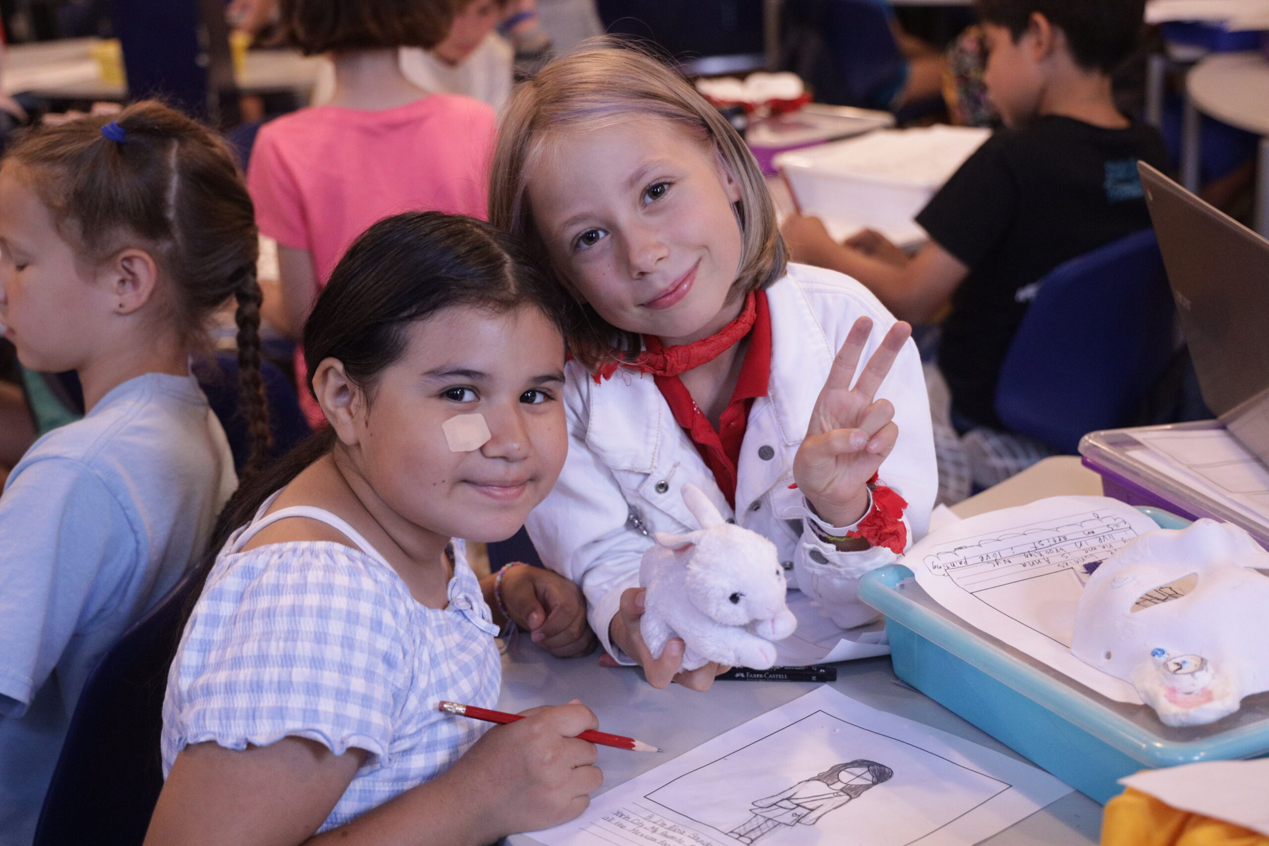 Alicia (left) and Anna (right) smile for the camera. Anna is giving a peace sign.