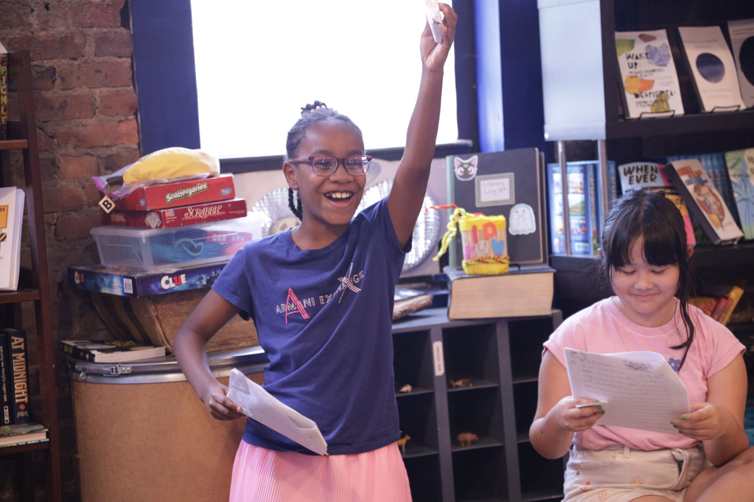 A student smiles during a dramatic performance of their writing.