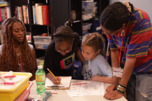 Two students work with two volunteers on their mystery comic at the 826NYC secret library.